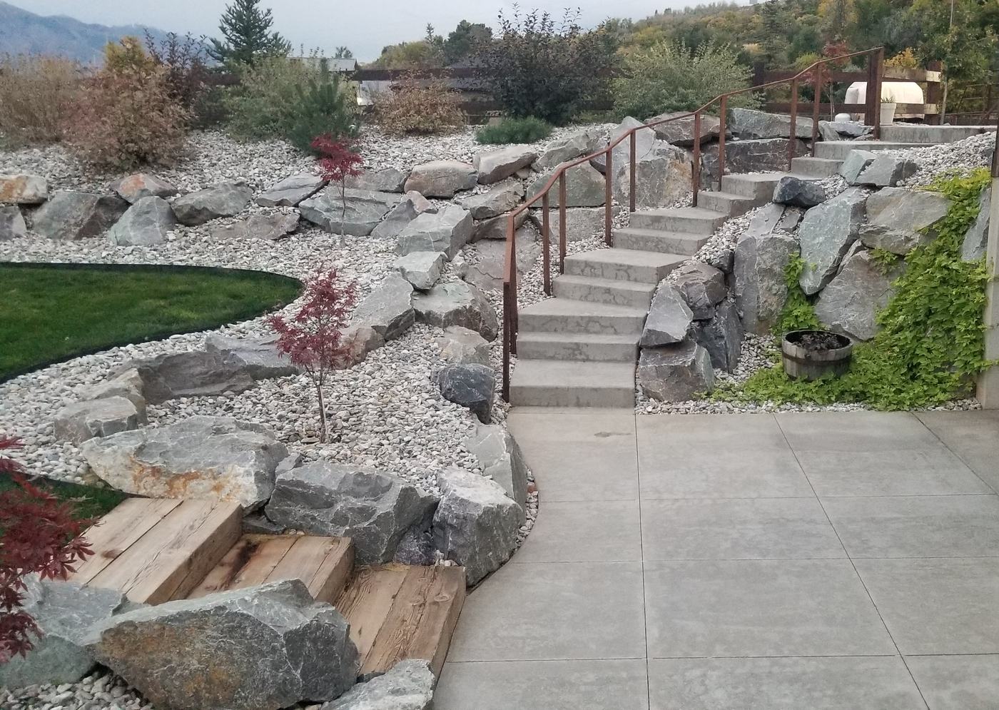 Finished estate landscape with boulder terracing, gravel beds, concrete steps and lawn