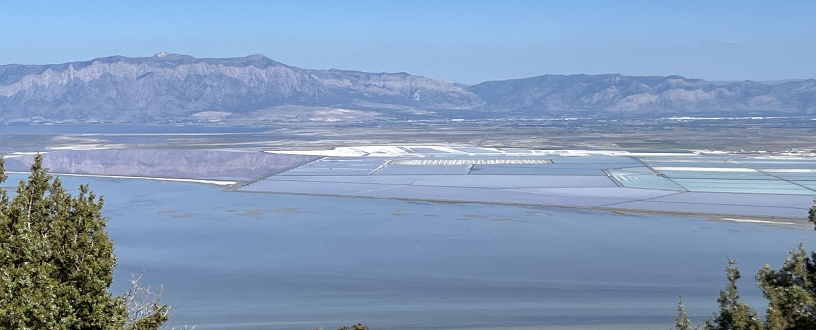 Evaporation ponds laid out across the Great Salt Lake with the Wasatch range beyond
