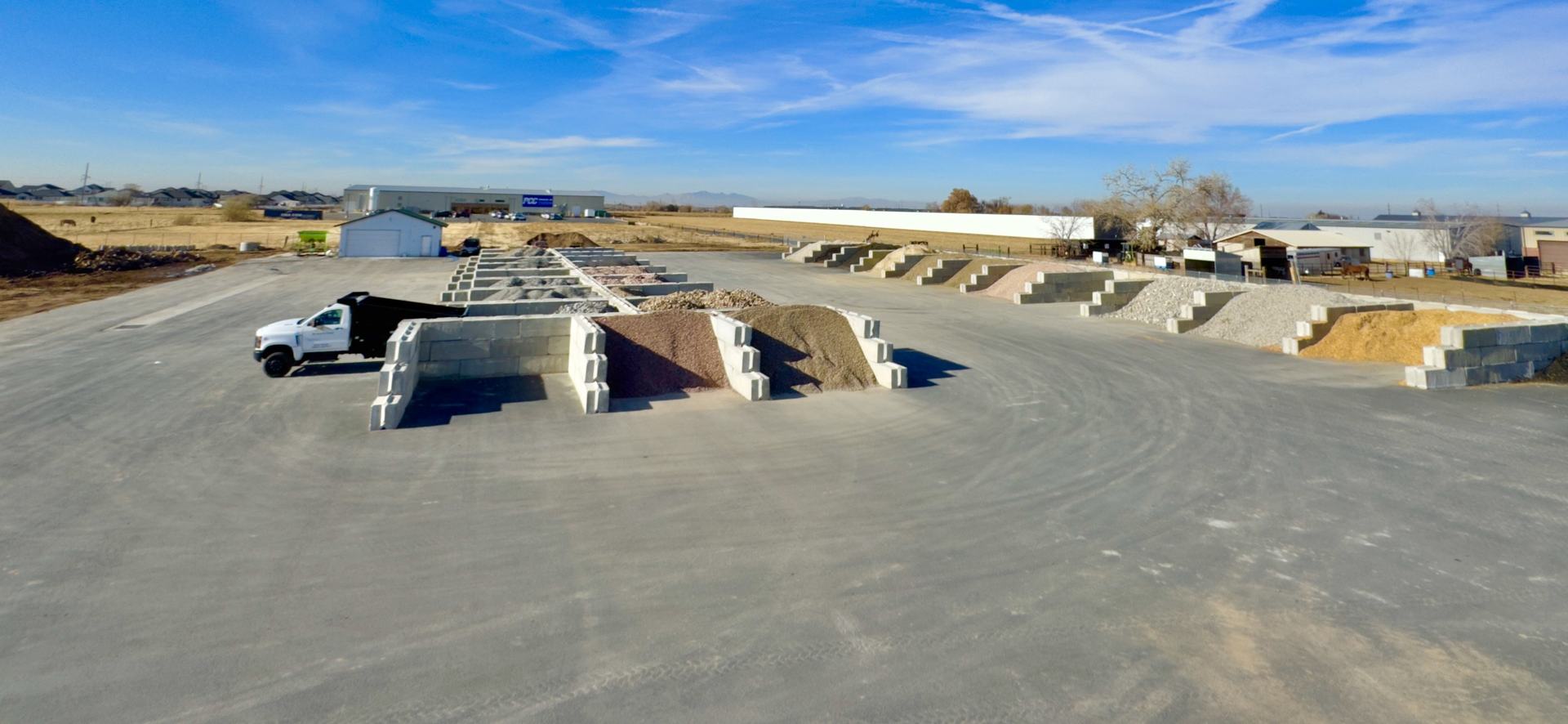 Wide view of the Greystone retail yard with separated material bins and a delivery truck loading