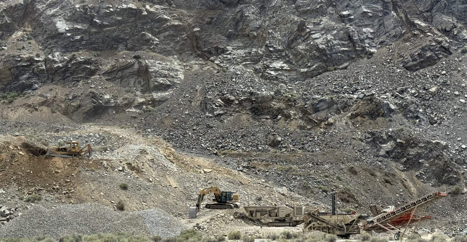 Northshore pit operation — excavator and crushing plant working beneath a quarry face