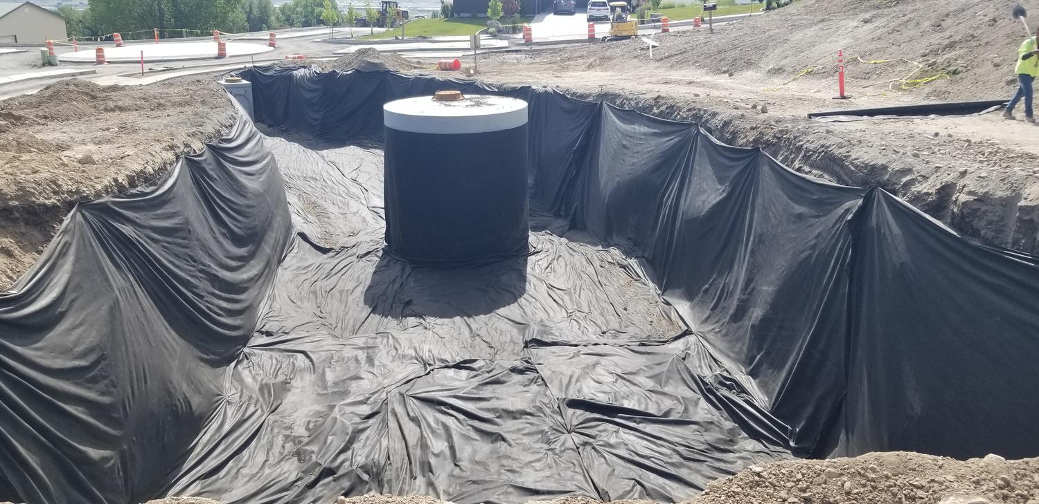 Lined excavation with a concrete vault set in place during subdivision utility installation
