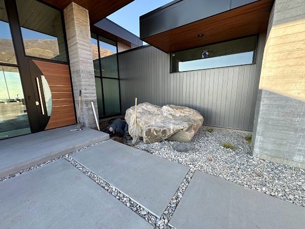 Signature boulder built into a water feature at the entry of a modern estate home